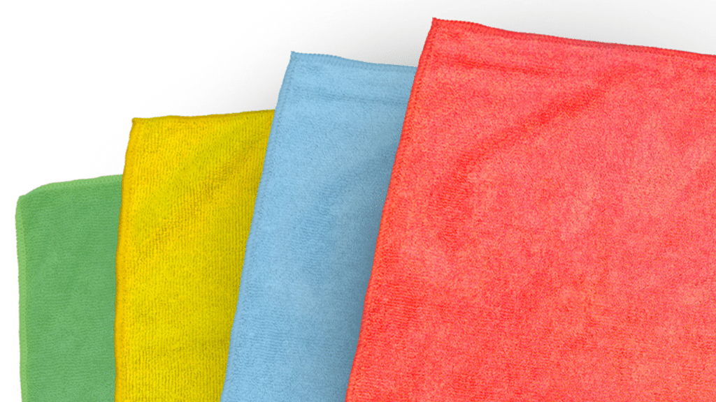 A set of four vibrant microfiber cloths, each in a different color. on a white backdrop