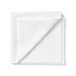 Top view of white LintNIL low lint patient wipes stacked with the top wipe folded over to the left