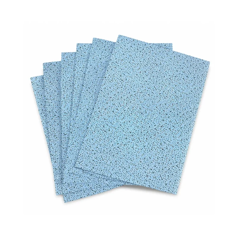 Textured blue oil absorbing wipes with a pattern fanned out on a plain background