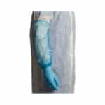 Side view of a person wearing a green glove and a white coat with a disposable blue sleeve protector