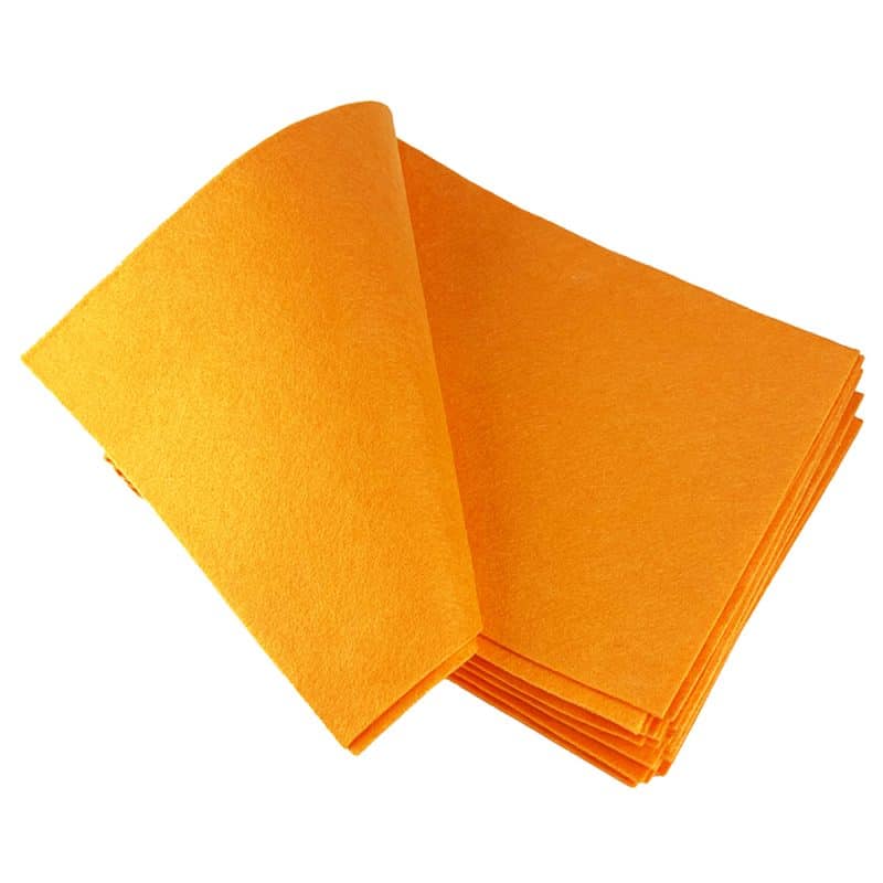 Top-down view of a stack of lively orange cloths, featuring the uppermost cloth elegantly curved to the left, set against a plain background.