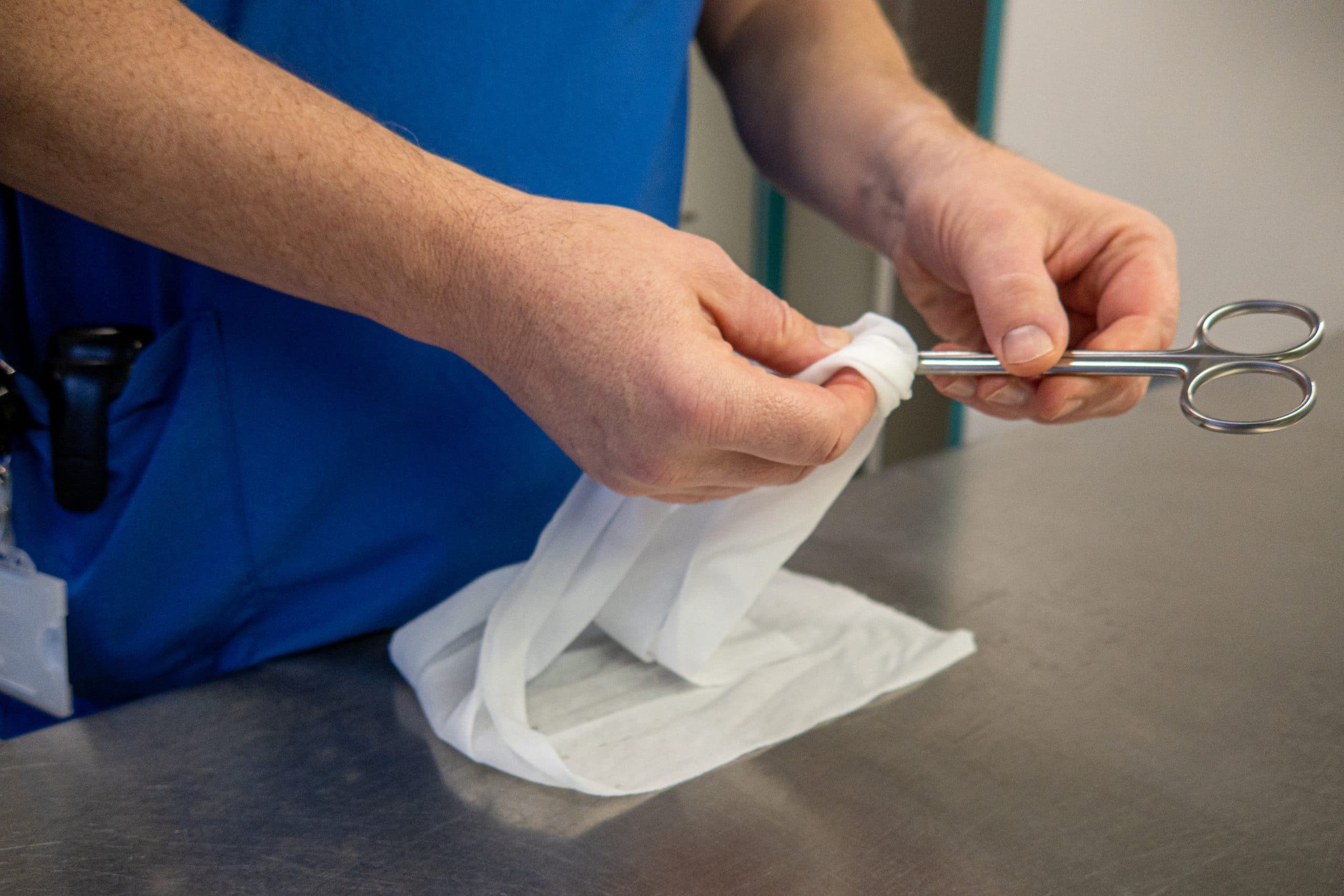 a surgical instrument is cleaned with a white cloth