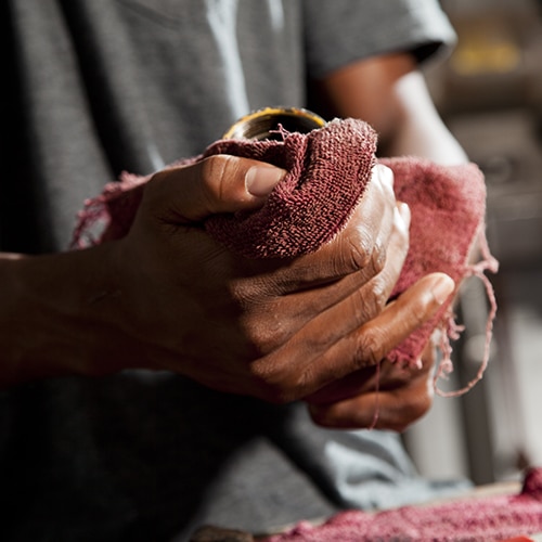 A man wiping his hand with a red cloth