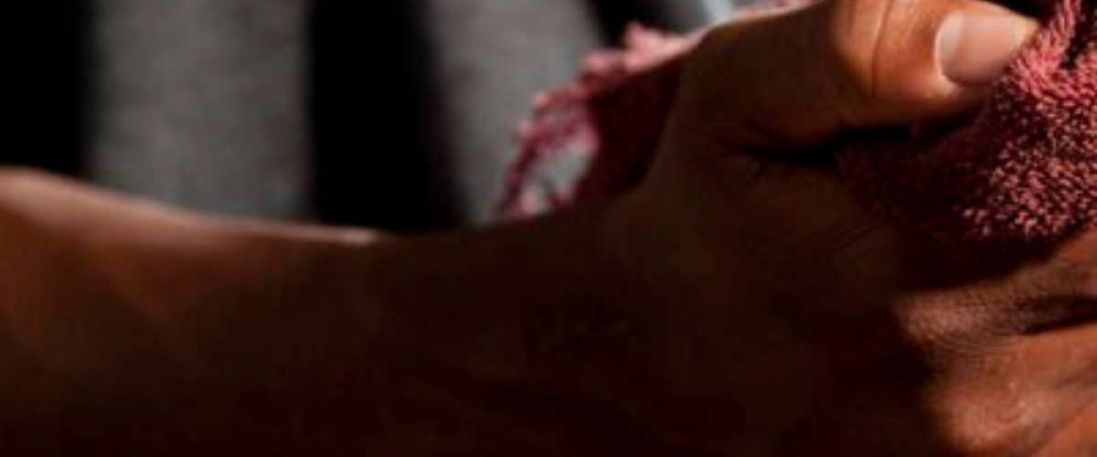 A man wiping his hand with a red cloth