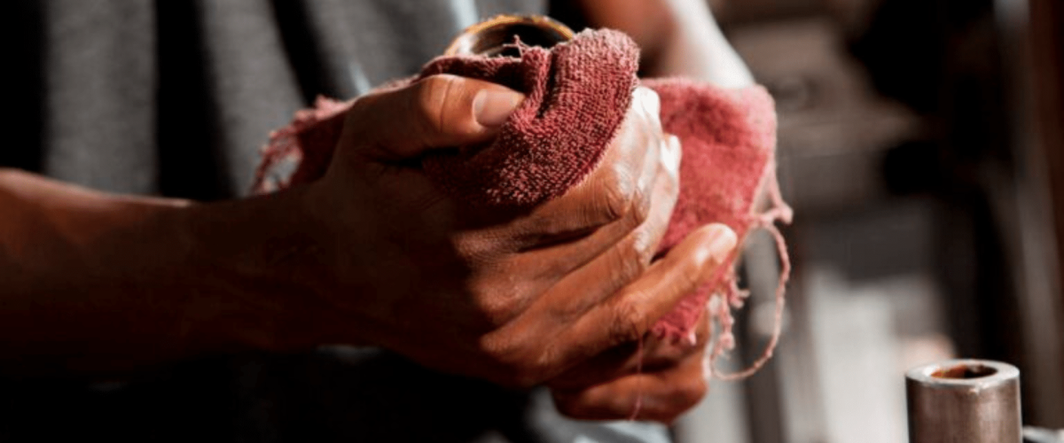 A man wiping his hand with a red cloth