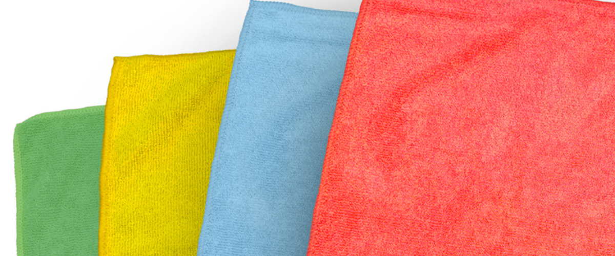 A set of four vibrant microfiber cloths, each in a different color. on a white backdrop